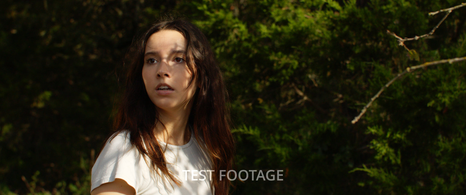 Ava looking nervously over her shoulder while in the forest
